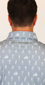 Back view of a man wearing a light grey collared shirt with white skeletons playing golf all-over print and the 'Mulligan Hooligan.' brand name printed on the inner neck label.