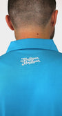 Back view of a man wearing a bright blue collared polo shirt with 'Mulligan Hooligan' embroidered in white on the upper back, against a plain light background.