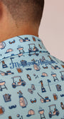 Close-up of a person wearing a light blue Best Dad By Par short-sleeve shirt with a golf-themed all-over print and vertical 'Mulligan Hooligan' text on the collar.