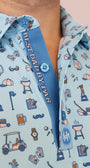 Close-up of a light blue patterned button-up shirt with a blue placket reading 'BEST DAD BY PAR' and a small circular logo patch.