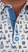 Close-up of a man wearing a white button-down shirt with a blue and navy Dad golf-themed print, featuring a collar, and a custom planchet saying ''Best Dad By Par'' blue placket, and a white chest patch with a circular 'NM' logo.