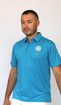 A man wearing a bright blue polo shirt with a golf-themed logo on the left chest that says ''BEST DAD BY PAR'', paired with white pants, standing against a plain light background.