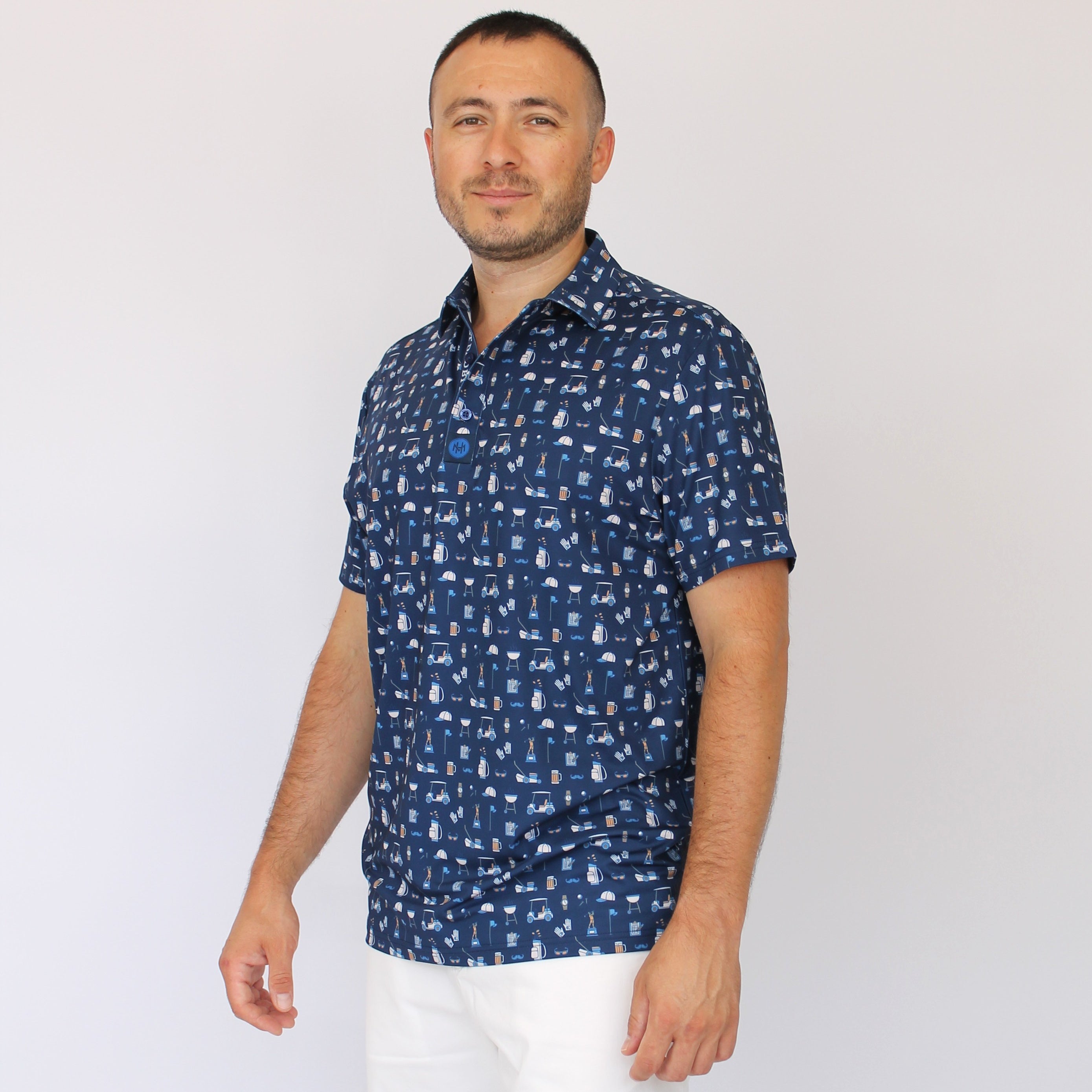 A man wearing a navy blue Best Dad By Par short-sleeve button-up shirt with a white golf dad pattern, paired with white shorts, standing against a plain white background.