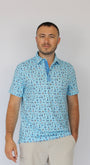A man wearing a light blue short-sleeve polo shirt with Golf dad repeating blue pattern, paired with light beige trousers, photographed against a plain white background.