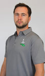 A man wearing a gray short-sleeve polo shirt with a green and white golf logo on the left chest saying 'Best Grandpa by Par', photographed against a plain light gray background.