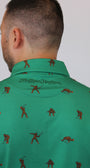 Close-up of a person wearing a green collared shirt with a repeating brown golfers Bigfoot pattern and 'Mulligan Hooligan' text on the collar, against a plain light background.