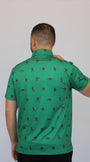 A man viewed from behind wearing the Mulligan Hooligan Bigfoot green short-sleeve polo shirt with a repeating brown golfer silhouette pattern, set against a plain light gray background.