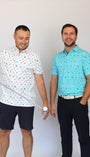 Two men standing side by side wearing matching beach-theme & golf-theme patterned short-sleeve button-up shirts, one in white and the other in light blue, with dark pants, against a plain light background.