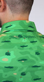 Close-up back view of a man wearing a green collared shirt with an alligator camouflage pattern and the 'Mulligan Hooligan' logo on the collar.