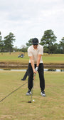 Person playing golf on a green course with trees in the background in A Mulligan Hooligan Polo with chest graphic that says: ' It  Takes a Lot of Balls to Play the way I do' 