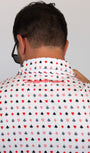 A man viewed from behind wearing a white short-sleeve button-up shirt with an all-over playing card suit pattern in red and black, featuring the brand name 'Mulligan Hooligan' printed in red script across the upper back.
