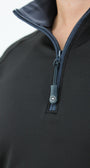 Close-up of a black pullover with a zipper and visible brand logo on a white background