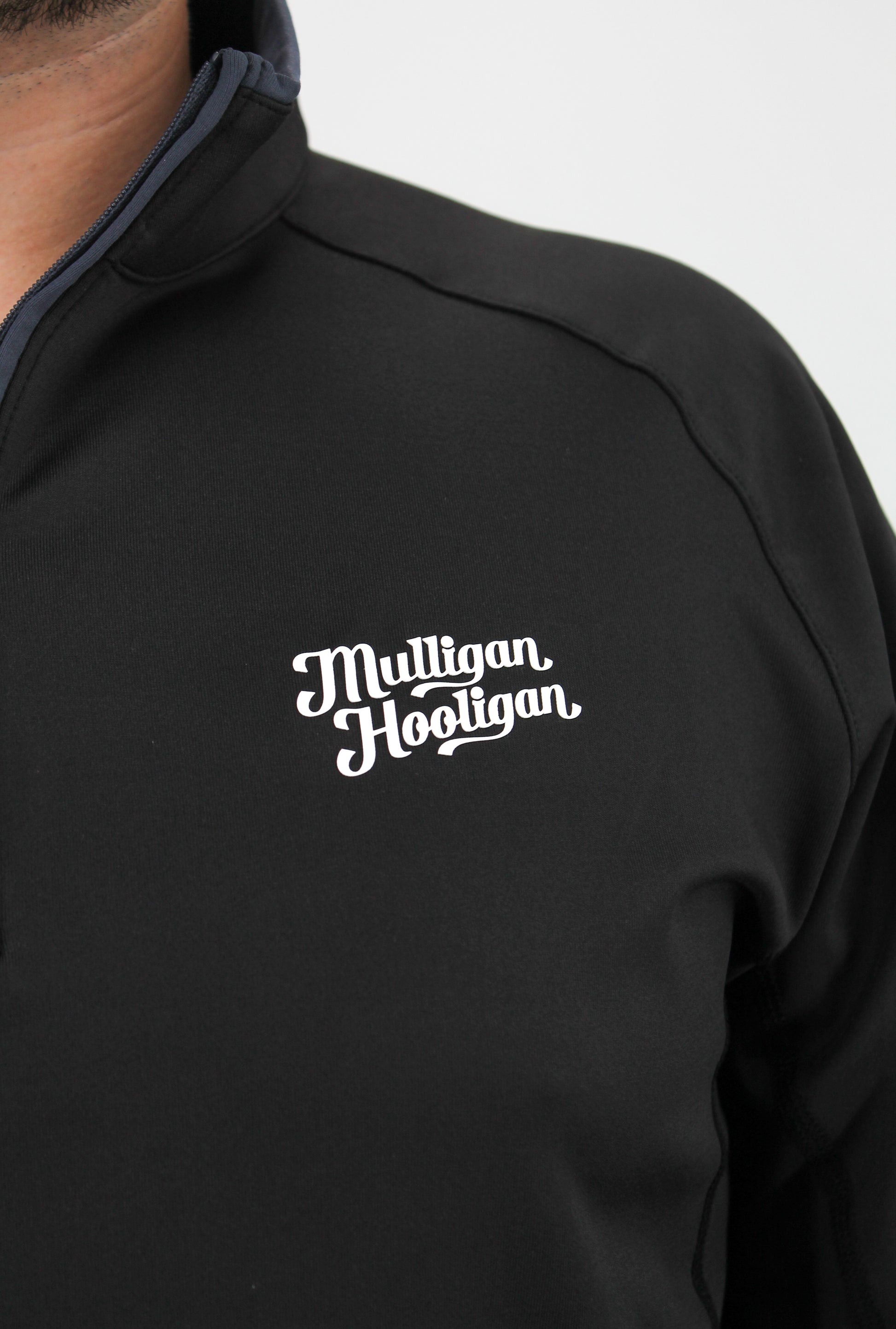 Black jacket with 'Multllgan Hoolllgan' logo on a white background