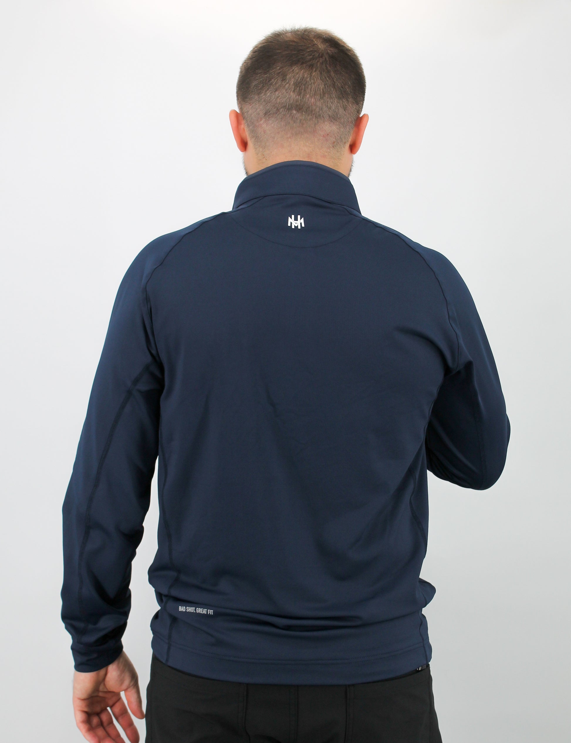 Man wearing a navy blue jacket with a logo on the back against a white background