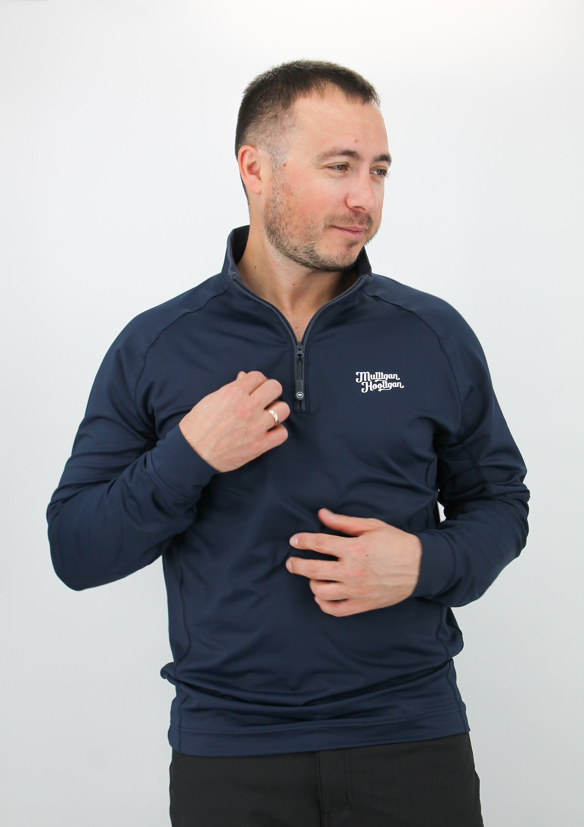 Man wearing a navy blue pullover with a logo on a white background