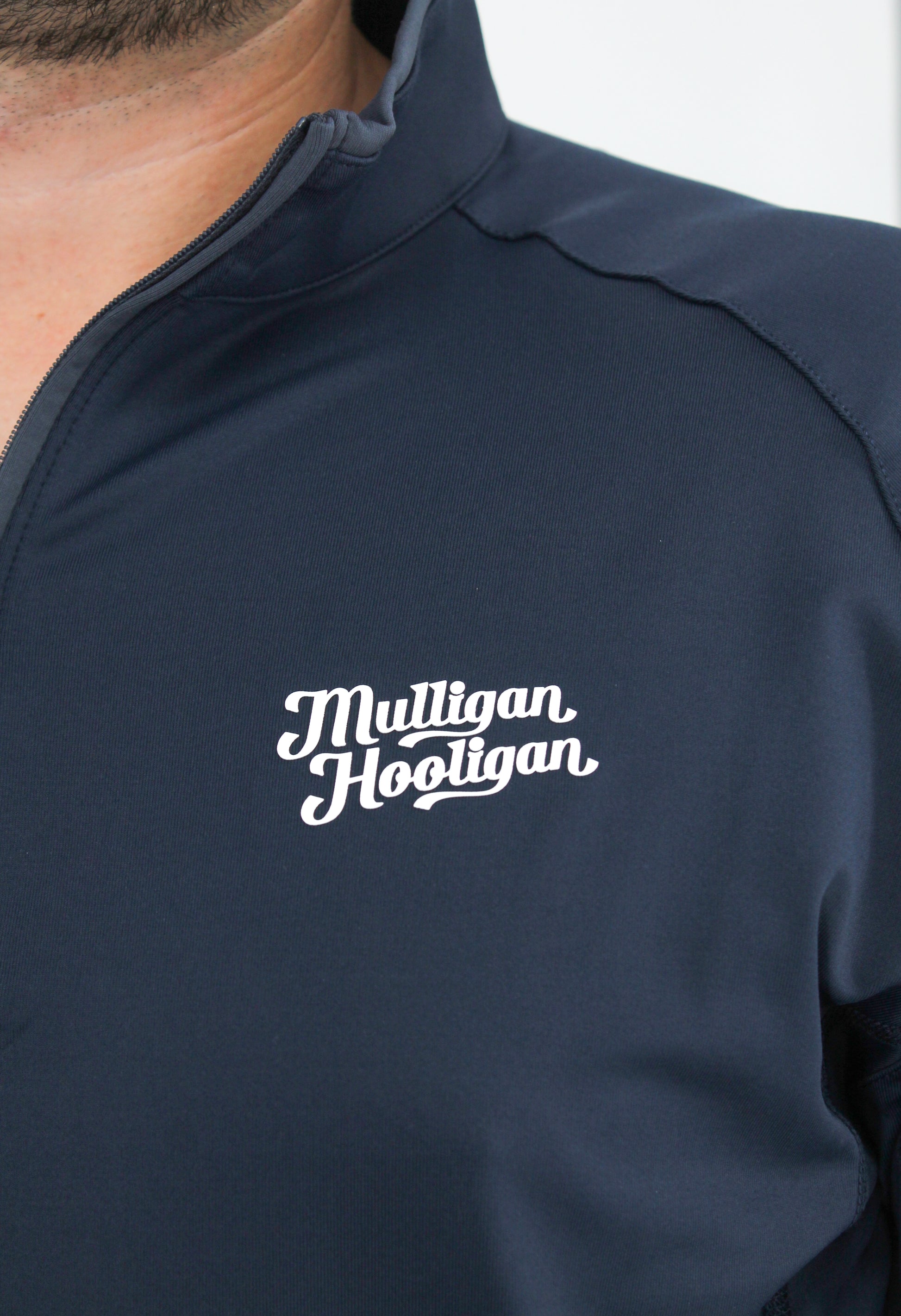 Navy blue jacket with 'Mulligan Hooligan' logo on a white background