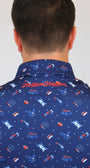 Back view of a man wearing a navy blue collared shirt with a red and white patriotic pattern of rockets, fireworks, and stars. The brand name 'Mulligan Hooligan' is embroidered in red on the back of the collar.