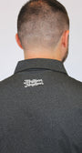 Back view of a man wearing a dark gray textured collared shirt with 'Mulligan Hooligan' embroidered in white script on the upper back, against a plain light gray background.