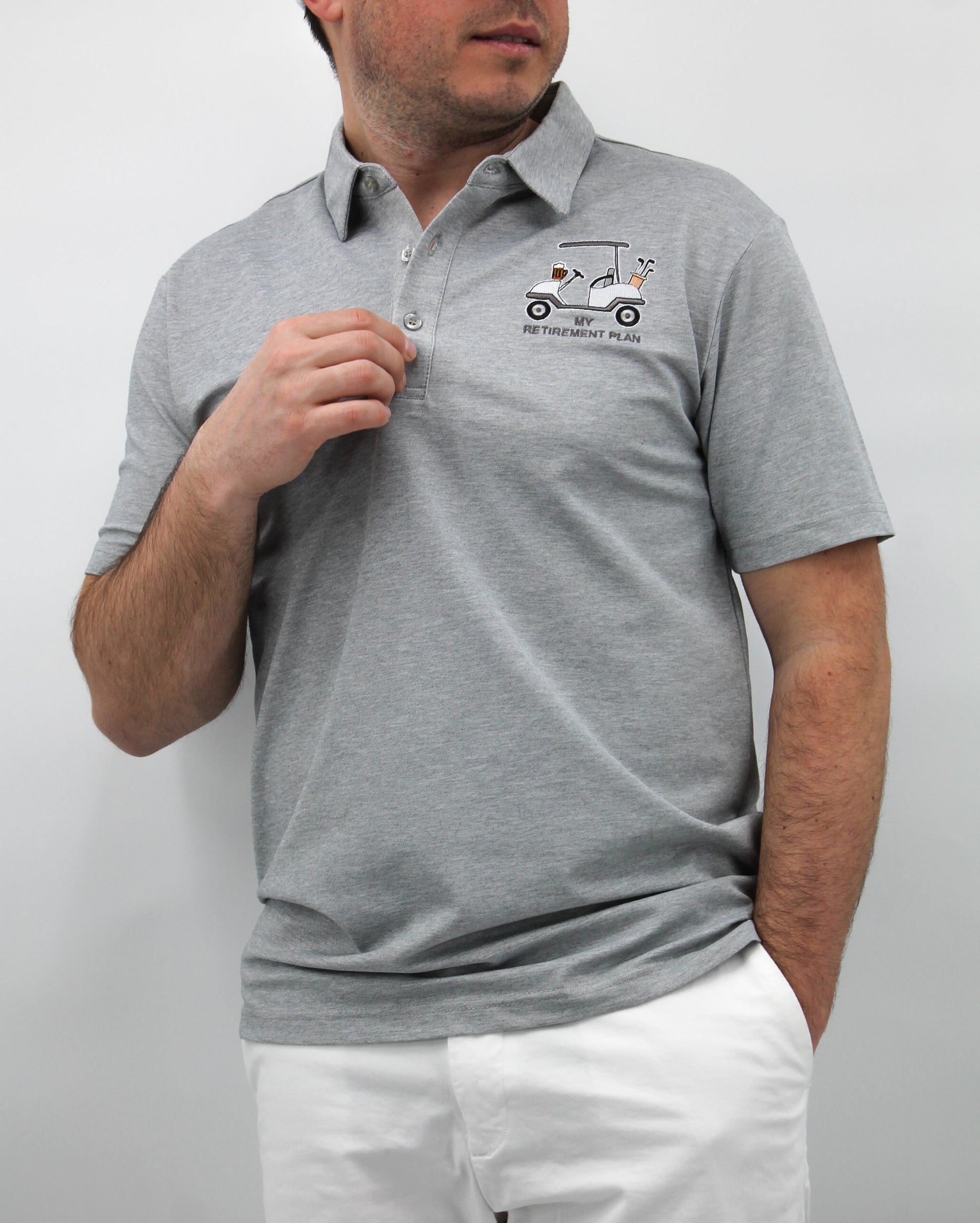 A man wearing a gray polo shirt with a graphic design in the center, standing against a white background.