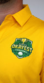 Close-up of a person wearing a bright yellow polo shirt with a green and gold 'World's Okayest Golfer' chest graphic.