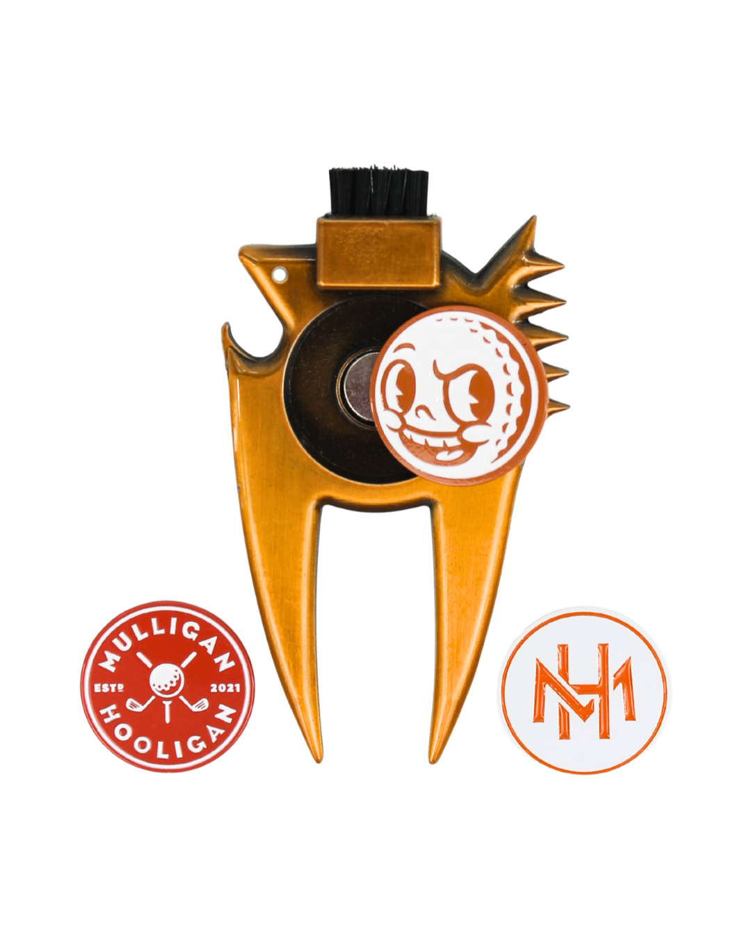 A gold-colored metal golf club head repair tool with a black cleaning brush on top, featuring a circular white and orange logo of a golf ball with a face-painted hole. Two circular orange and white stickers are shown below the tool on a plain white background.