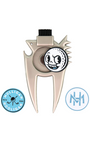 A metallic beige golf club head repair tool with a black cleaning brush on top and a circular golf ball charm featuring a cartoon face. Two circular blue and white badges are displayed on either side of the tool against a plain white background.