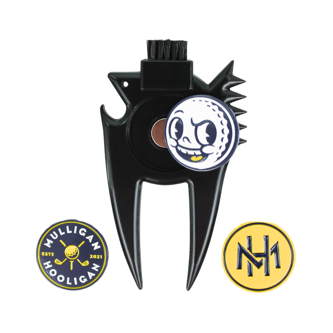 A black plastic golf club fairway divider with a built-in brush on the top, featuring a circular white and blue golf ball graphic on the center. Two circular metal emblems are shown below: one with the text 'MULLIGAN HOOLIGAN' in blue and yellow, and another with a yellow 'NH' monogram.