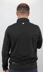 Person wearing a black jacket with a logo on the back against a white background