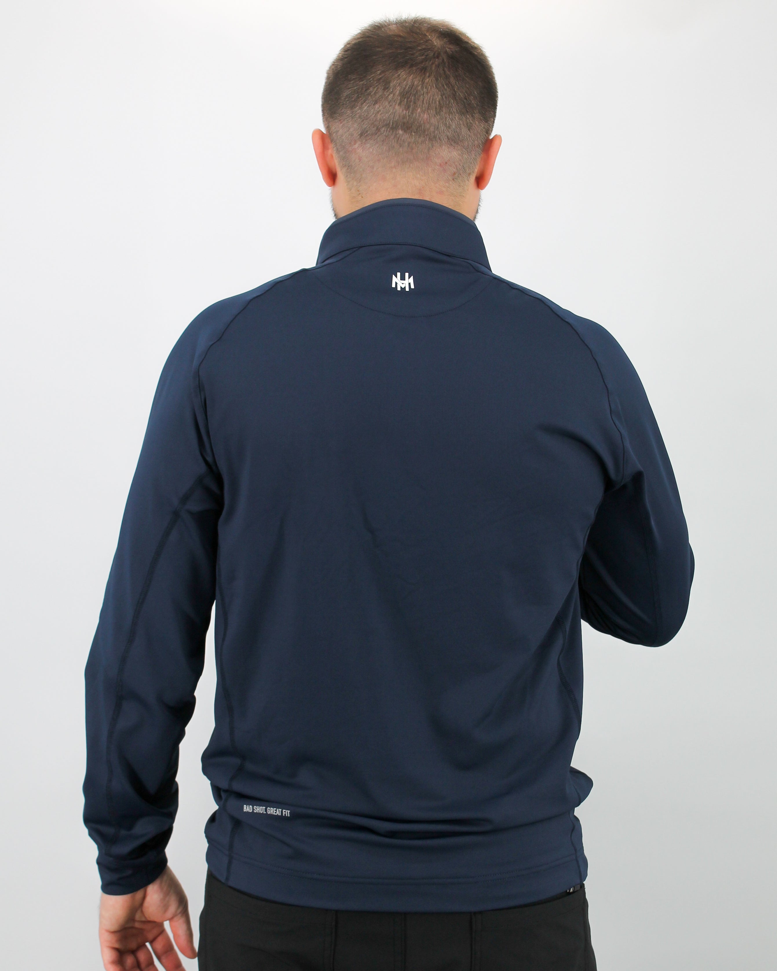 Man wearing a navy blue jacket with a logo on the back against a white background