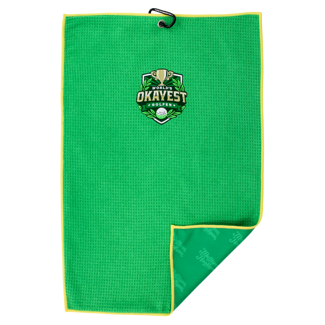 A bright green waffle-weave golf towel with a yellow border, featuring a 'Proud Okayest Golfers' embroidered logo in the center. The towel is shown flat against a white background with one corner folded over to display the patterned reverse side.